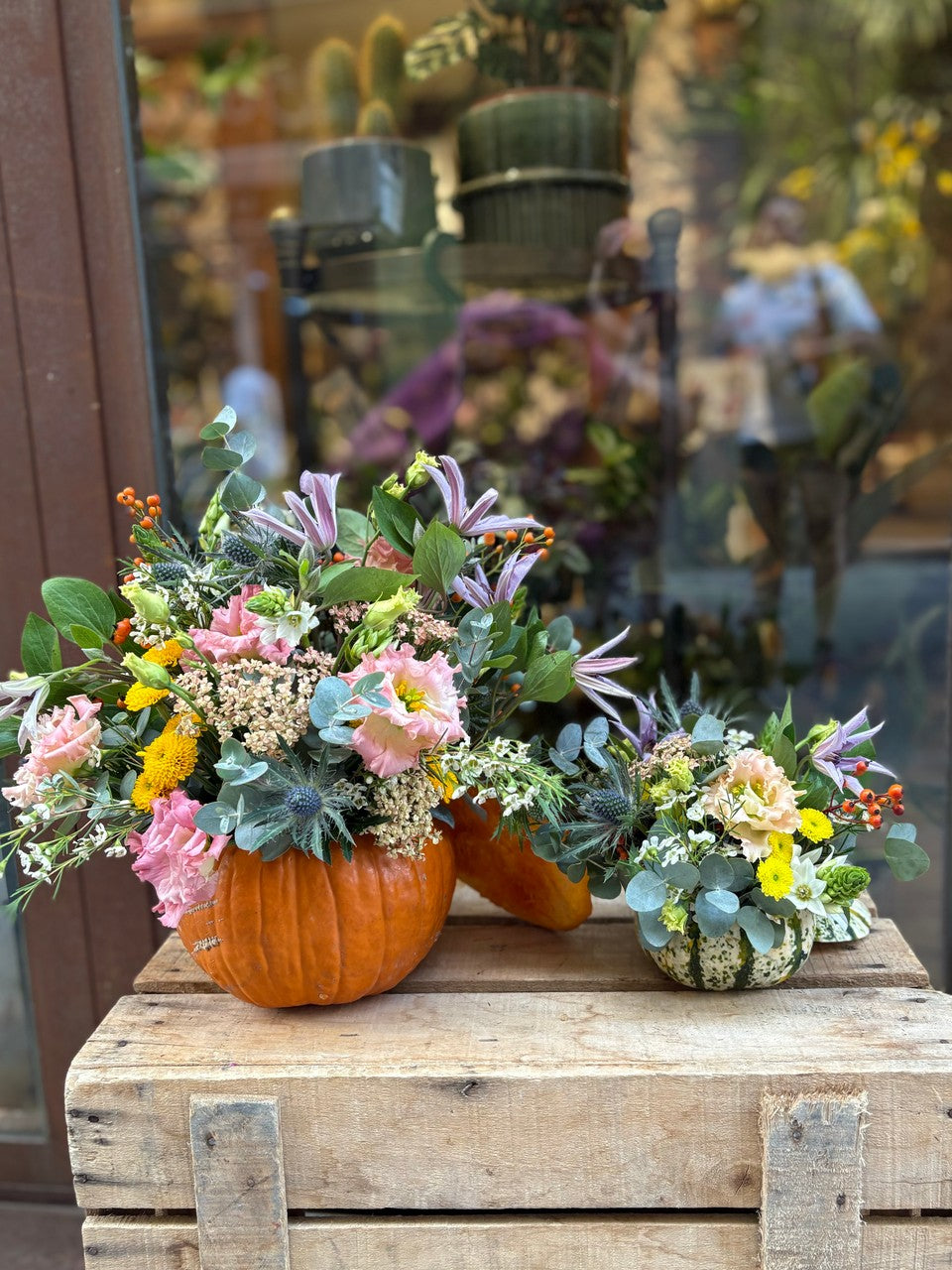 Calabazas naturales con flores de colores junto al escaparate de Lorena Marco