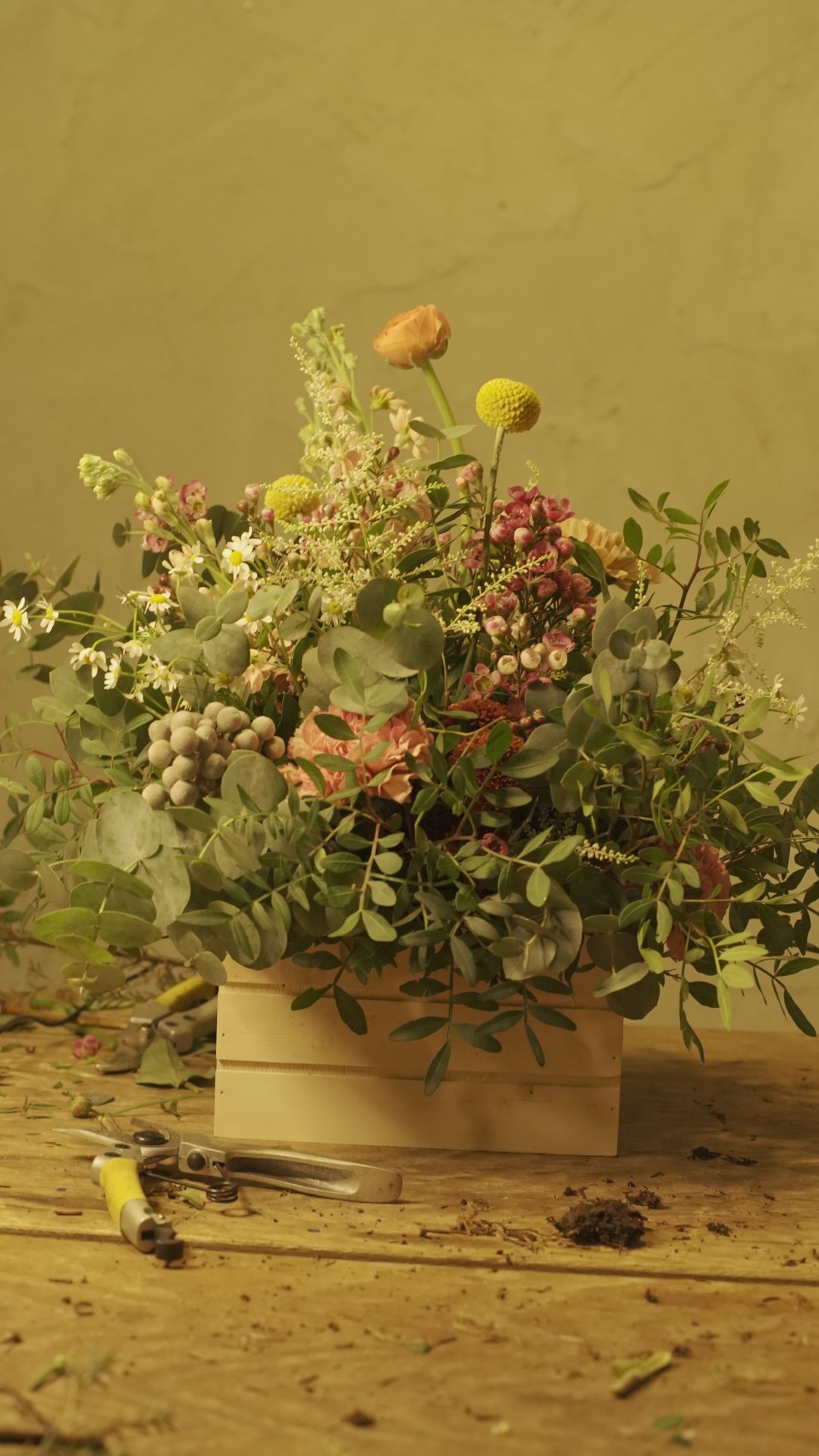 Tijeras y flores sobre la mesa del taller de Lorena Marco en Madrid